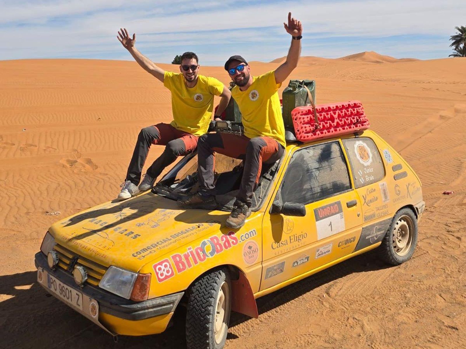 Júnior e Brais Rodríguez posan para a fotografía enriba do coche, un Peugeot 205.