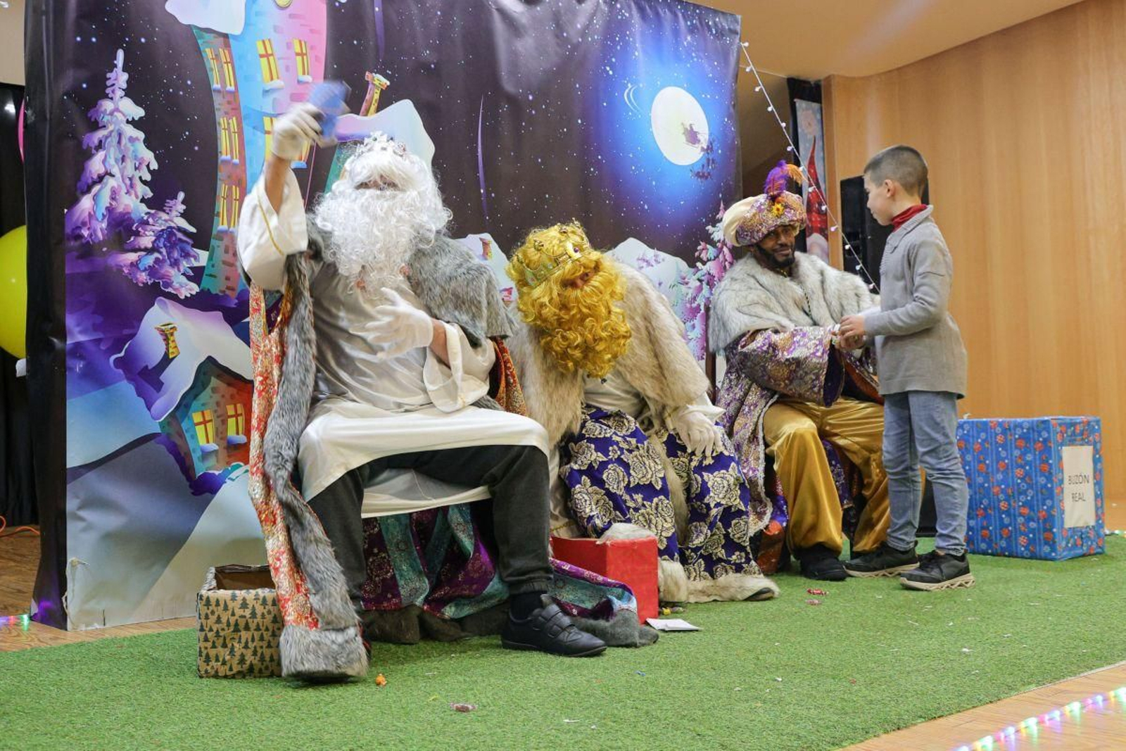 Un niño, siendo recibido por los Reyes Magos.