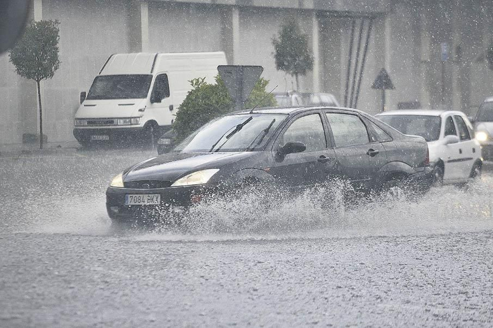 Un vehículo intenta avanzar entre el agua que anegaba las carreteras el domingo.