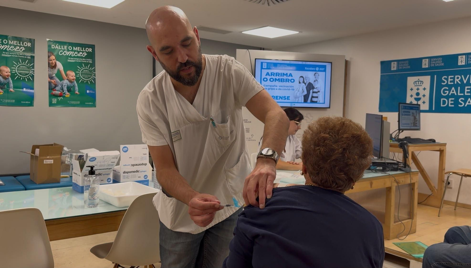 Un sanitario del área sanitaria vacuna a una ourensana contra la gripe.
