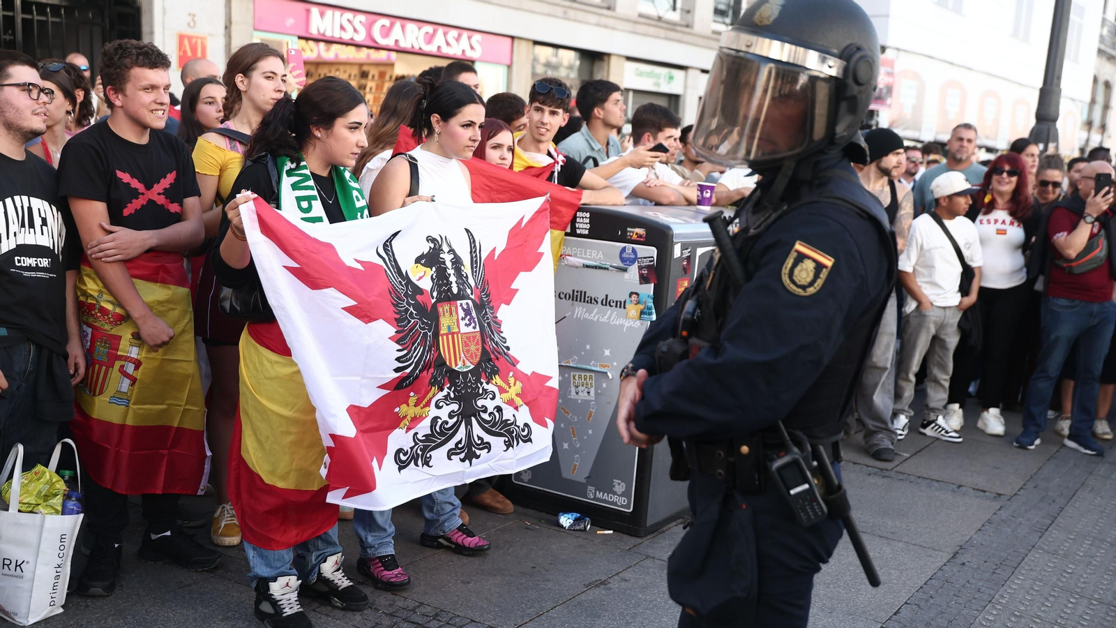Varias personas con la bandera de España increpan a los acampados por la vivienda en la Puerta del Sol