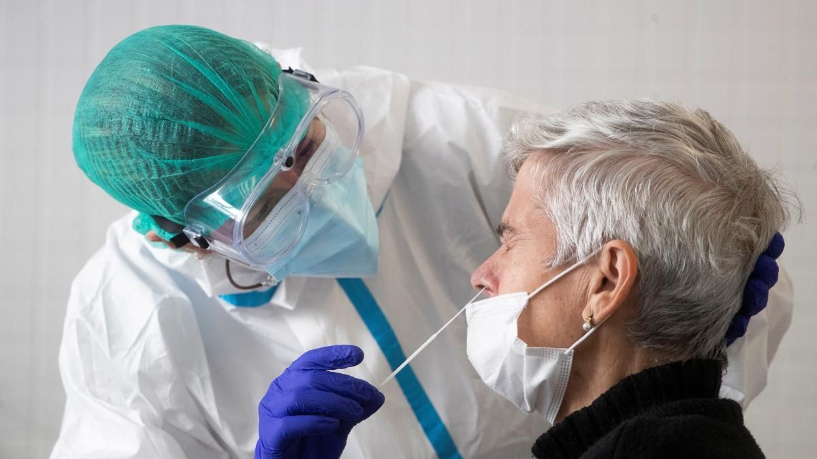 Una sanitaria realiza una prueba PCR a otra mujer en un hospital.