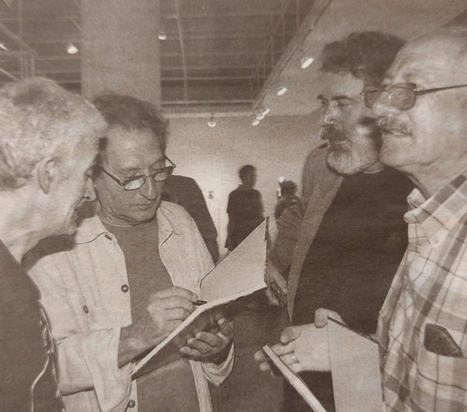 Manuel Buciños firma ejemplares del catálogo de la exposición.