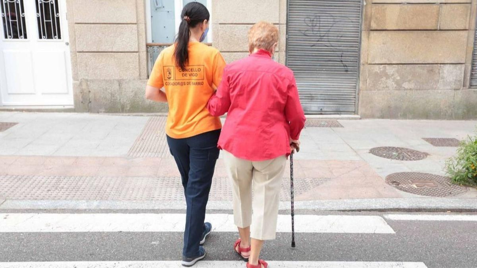 Una Coidadora de Barrio del Concello acompañando a una mujer.