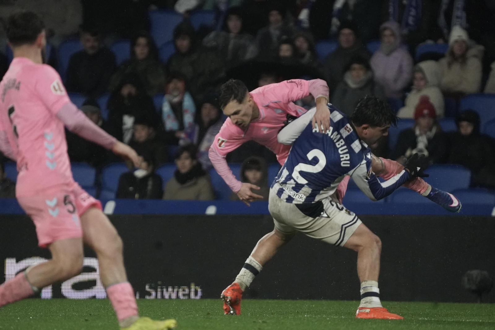 El céltico Bryan Zaragoza cae ante el donostiarra Aramburu durante el encuentro disputado bajo la lluvia en Anoeta.