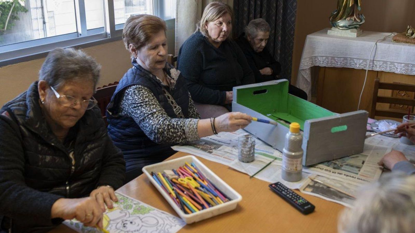 Las usuarias pintan cajas y flores.