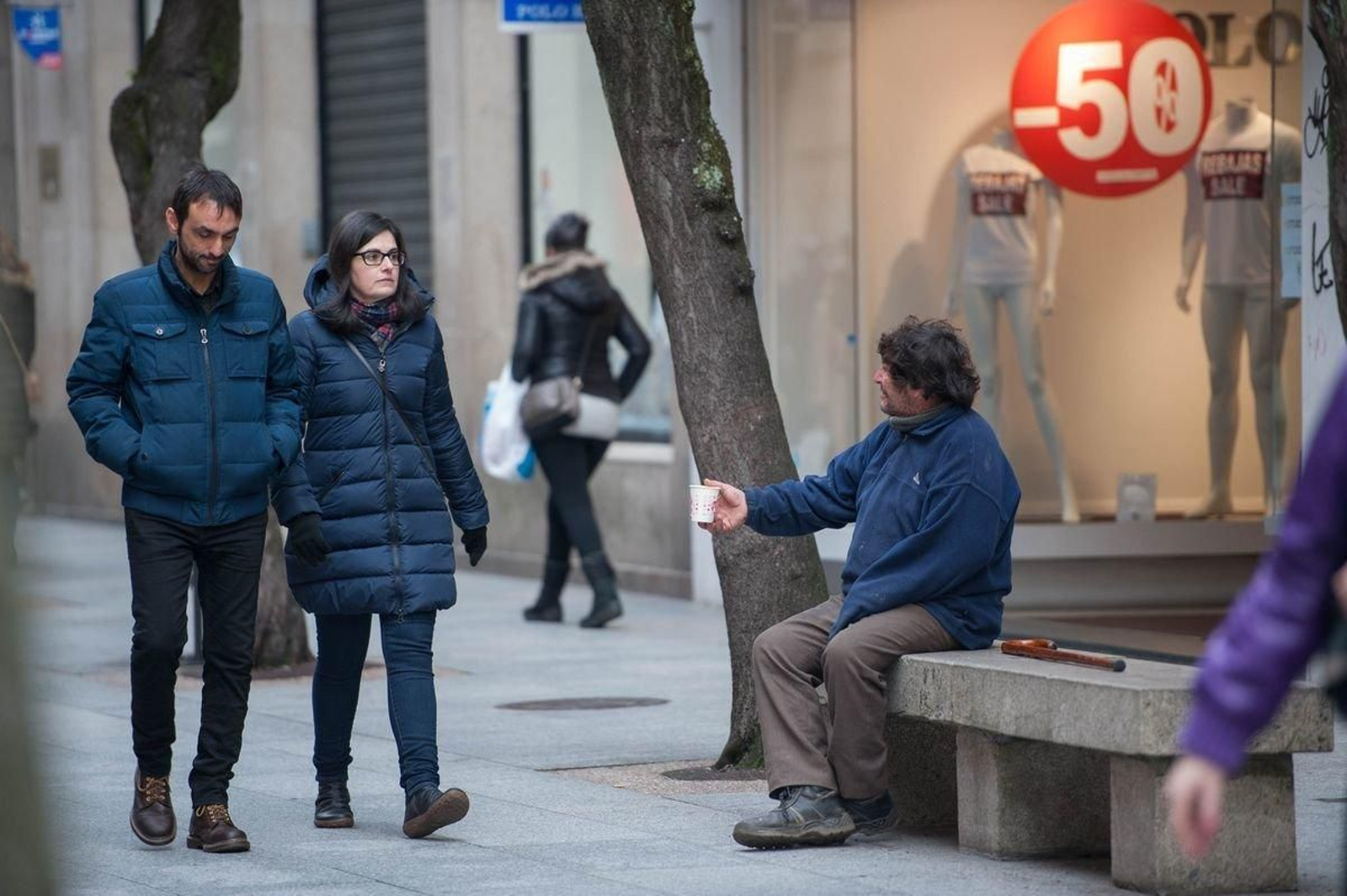 OURENSE (RÚA O PASEO). 07/01/2018. OURENSE. Dani, vecino de Barcelona con padre ourensano, pide limosna y ayuda en la calle del paseo sin demasiado resultado, mientras la gente paseo y compra en los comercios que han comenzado su temporada de rebajas. Ha dejado de fumar hace 14 días, come donde puede y espera reunir bastante dinero para poder dormir bajo un techo. FOTO: ÓSCAR PINAL