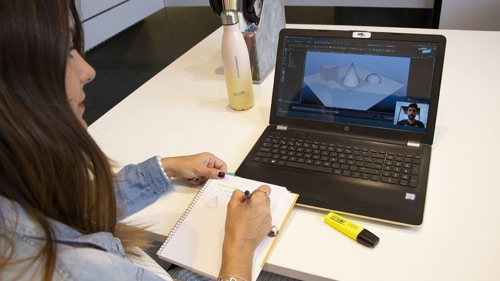 Una alumna asiste con su ordenador portátil a una clase online.