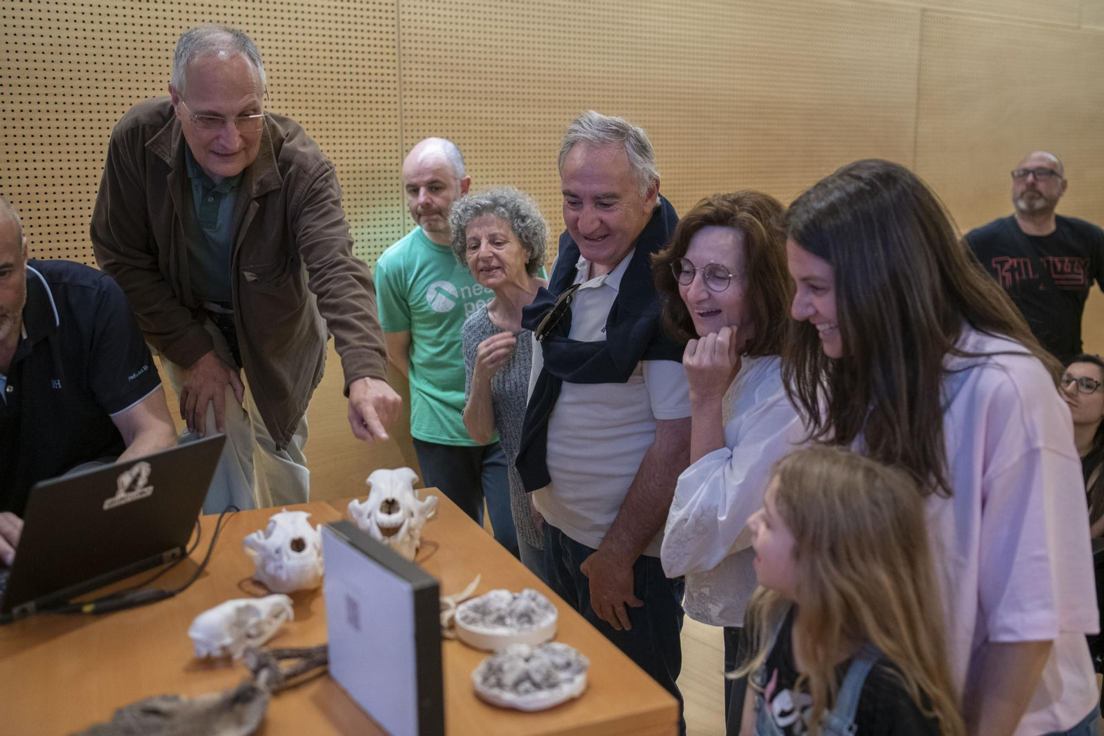 Público asistente interacuando con restos óseos de lobo ibérico.