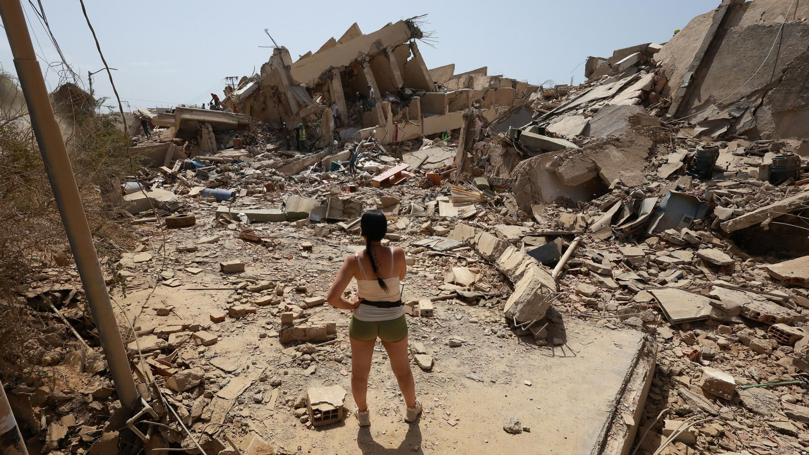 Una joven se encuentra frente a los escombros de las casas derrumbadas tras los devastadores terremotos en La Guaira