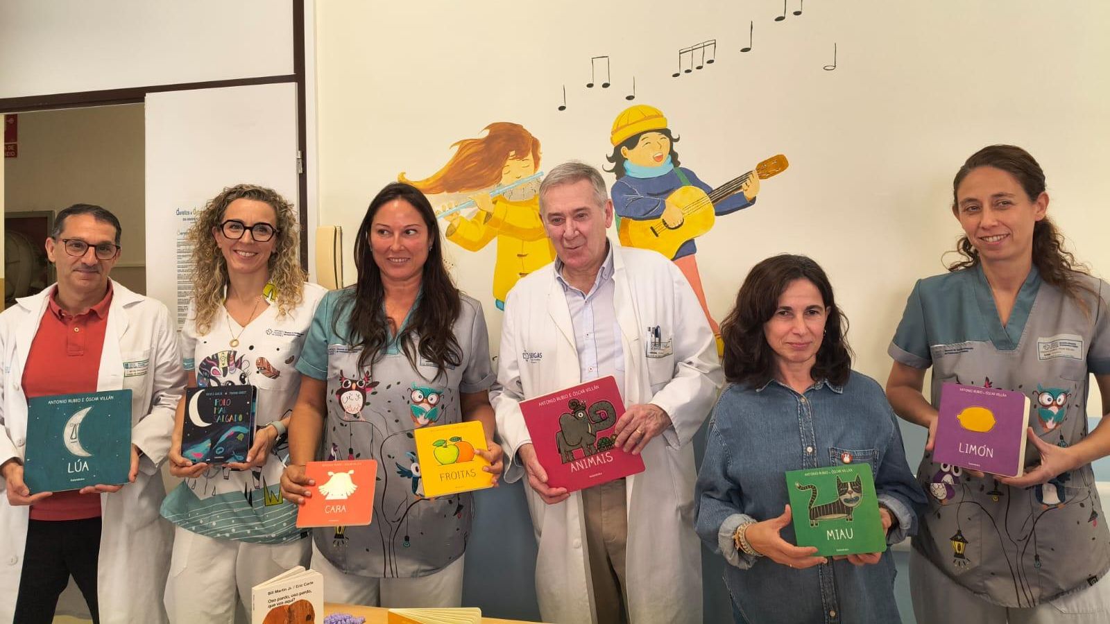 Profesionales sanitarios y de la editorial con libros que estarán en la biblioteva de Neonatología.