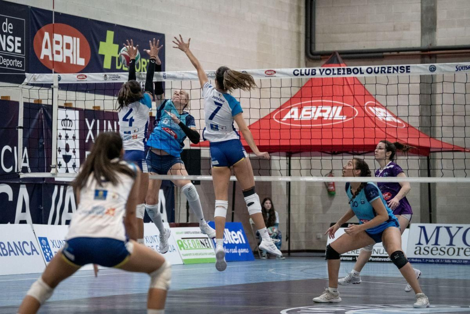 Rebeca Kruse, del Voleyourense, remata ante dos rivales del CD Voleibol Guía.