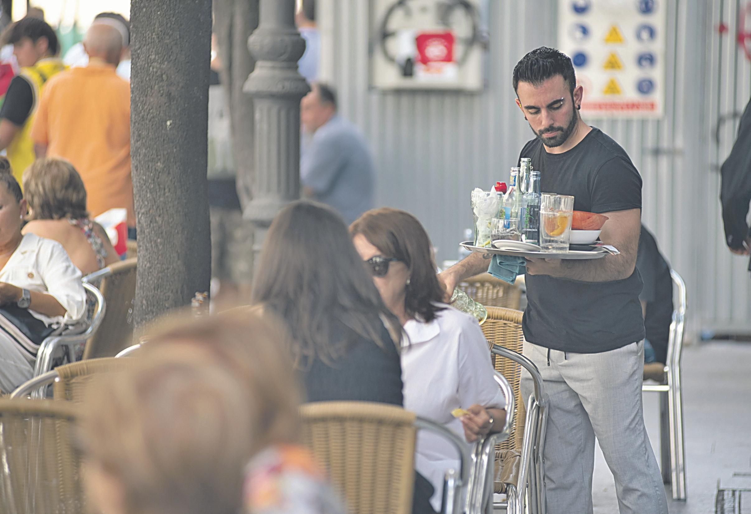 Un camarero sirve bebidas con hielo en una de las terraza del Paseo.