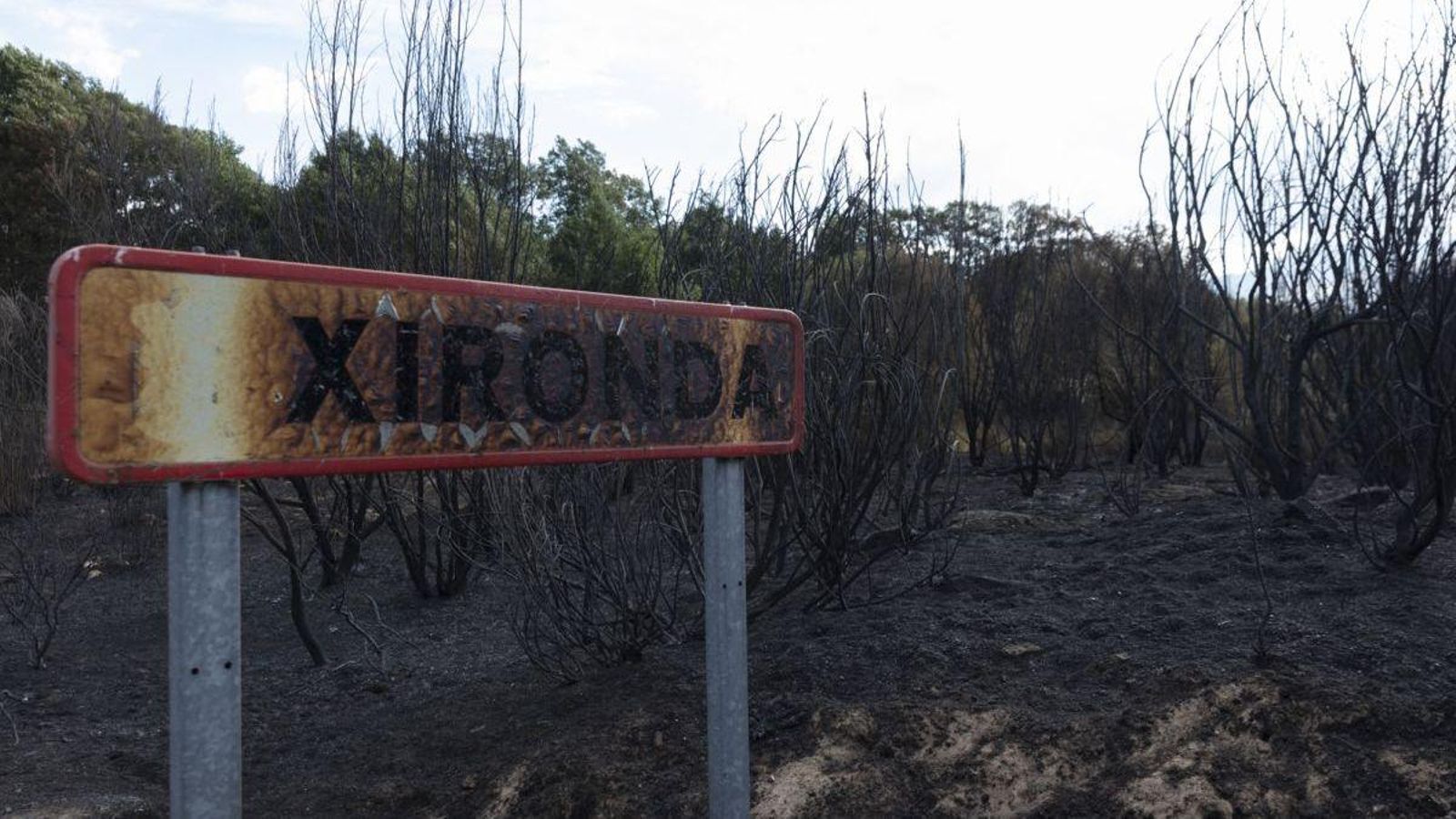 Cartel de entrada al pueblo de A Xironda totalmente calcinado por las llamas que rodearon la carretera