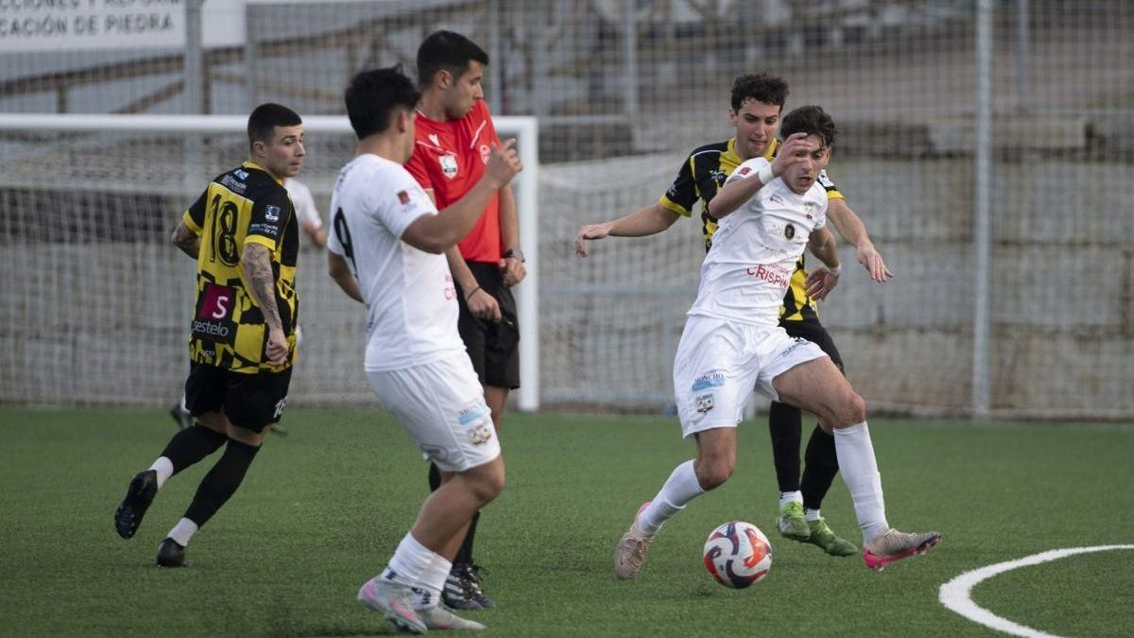 Gabri Losada, defensa del Atlético Arnoia, protege la pelota ante la presión de un contrario.