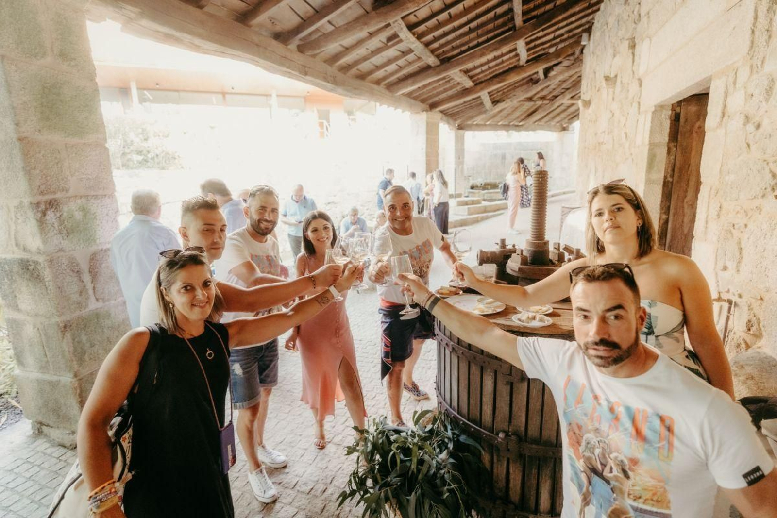 Un grupo de visitantes brinda en una de las bodegas de O Ribeiro.