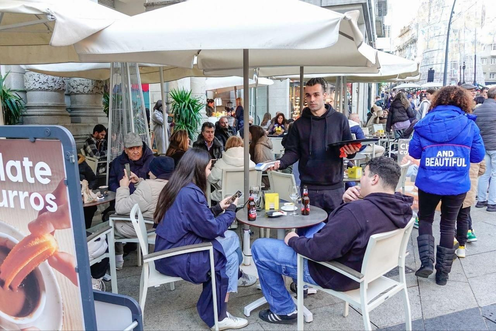 Un camarero cobra a una clienta en una terraza de Vigo. // Vicente Alonso