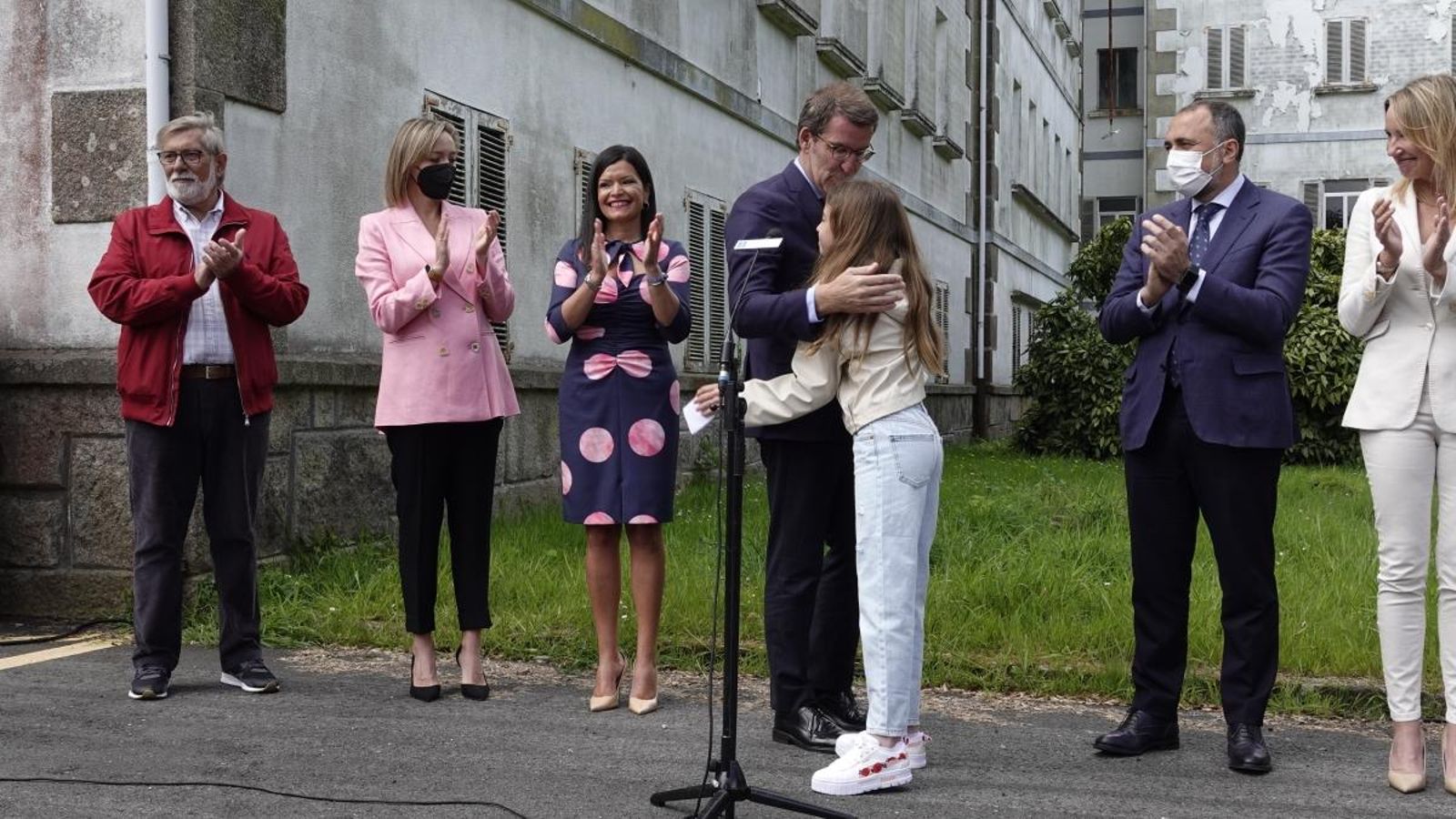 Feijóo abrazando a una joven de Mos tras recibir un regalo del municipio, junto a Arévalo, García y Comesaña.