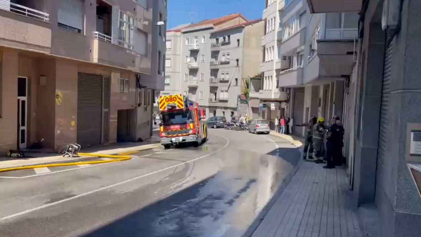 Los bomberos trabajan en la extinción del incendio declarado este jueves en un dúplex de la Estrada da Granxa, en Ourense.