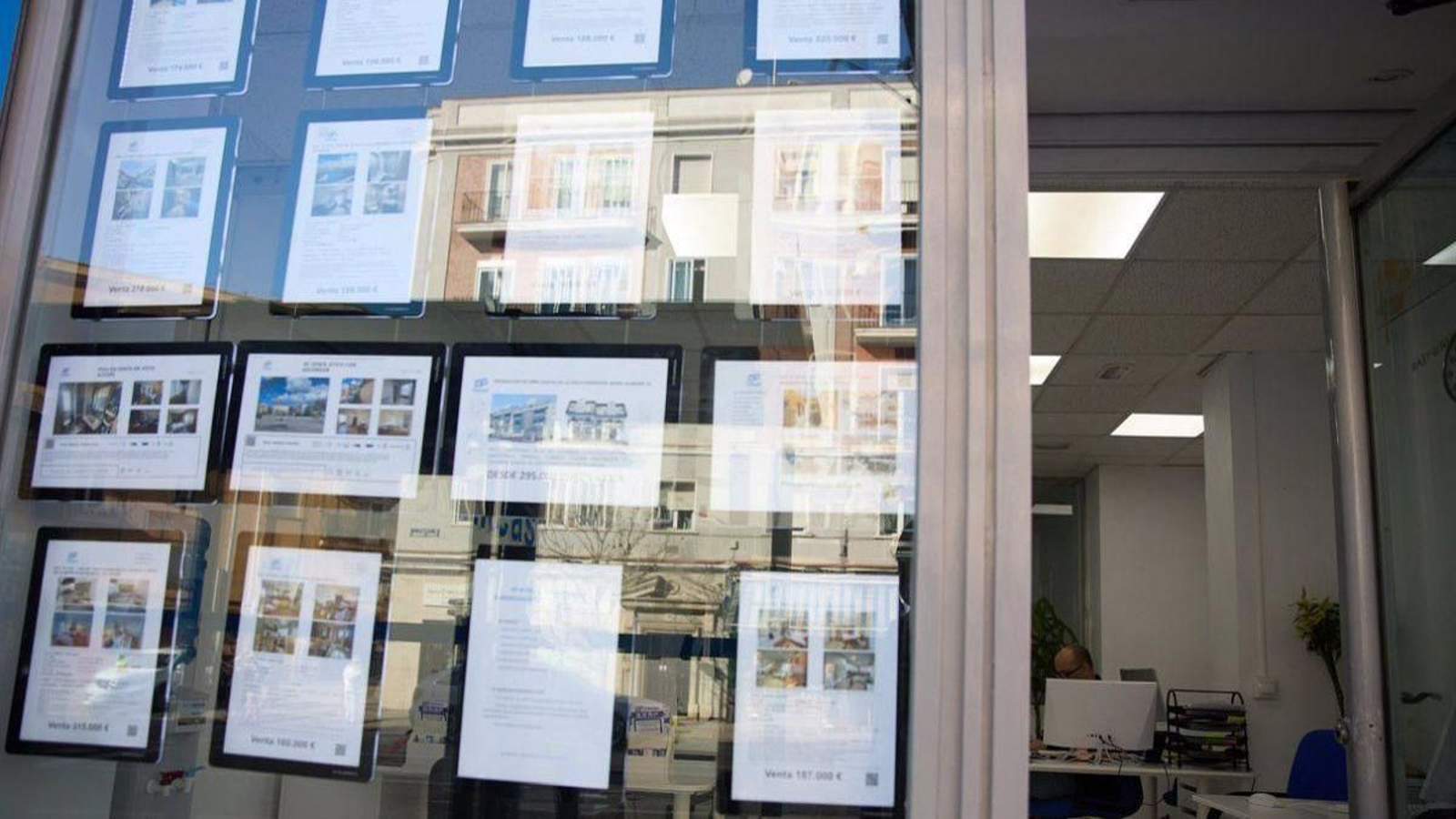 Escaparate de una inmobiliaria con la oferta de pisos para comprar y alquilar.