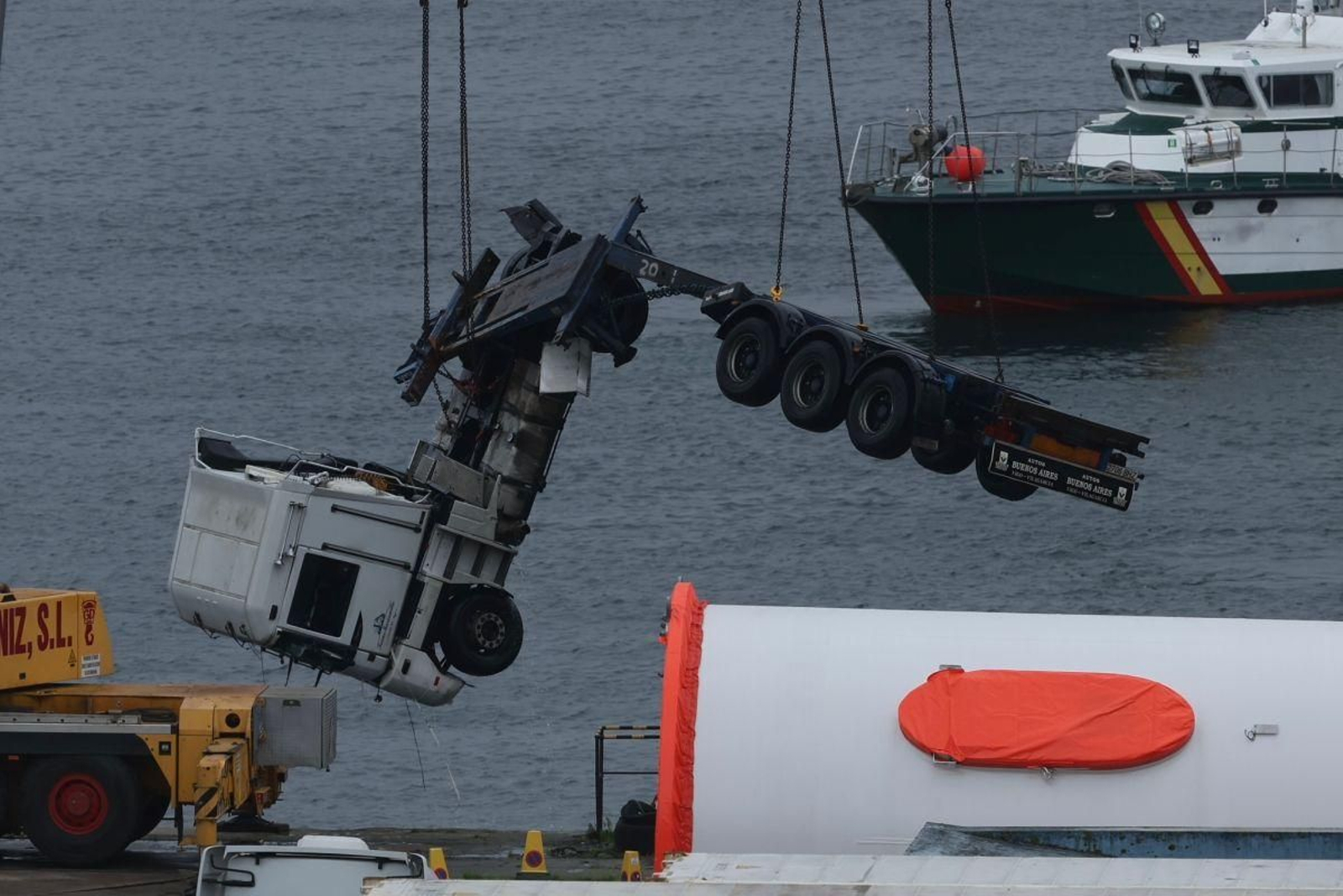 Momento del rescate del camión en aguas de Guixar, donde quedó sumergido tras la caída, hasta el muelle para ser inspeccionado por la Guardia Civil.