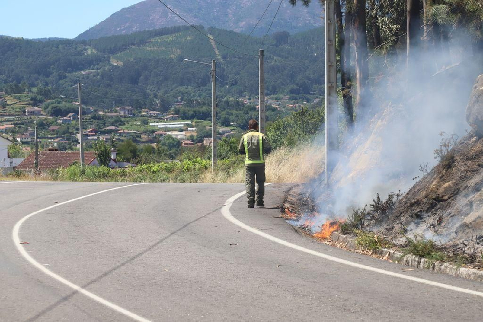 Agentes Forestales y Protección Civil en lugar de Portelo, Vilaza. Derecha, el fuego llegó hasta el arcén del vial
