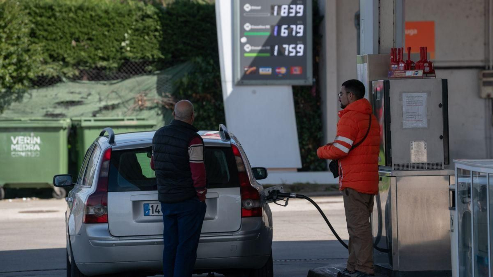 Un cliente portugués observa los precios del combustible mientras reposta en la estación de Feces de Abaixo (Verín).