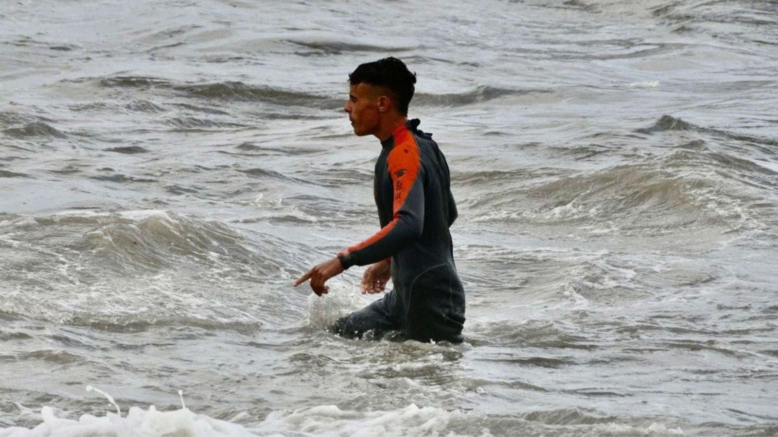 Un migrante marroquí camina al llegar a la orilla de la playa del Tarajal en Ceuta.