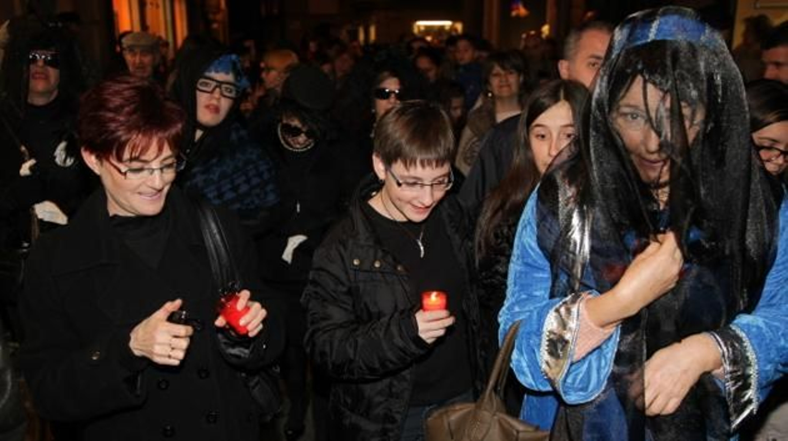 Un grupo de viudas portando velas
