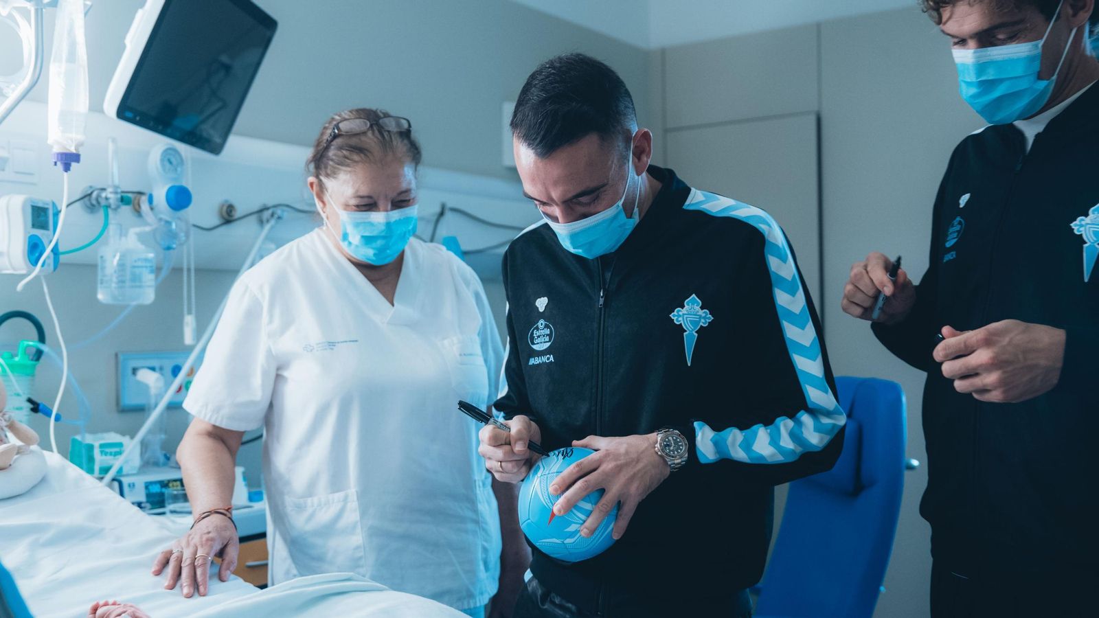 Iago Aspas asina un balón a un dos nenos do Hospital Álvaro Cunqueiro.