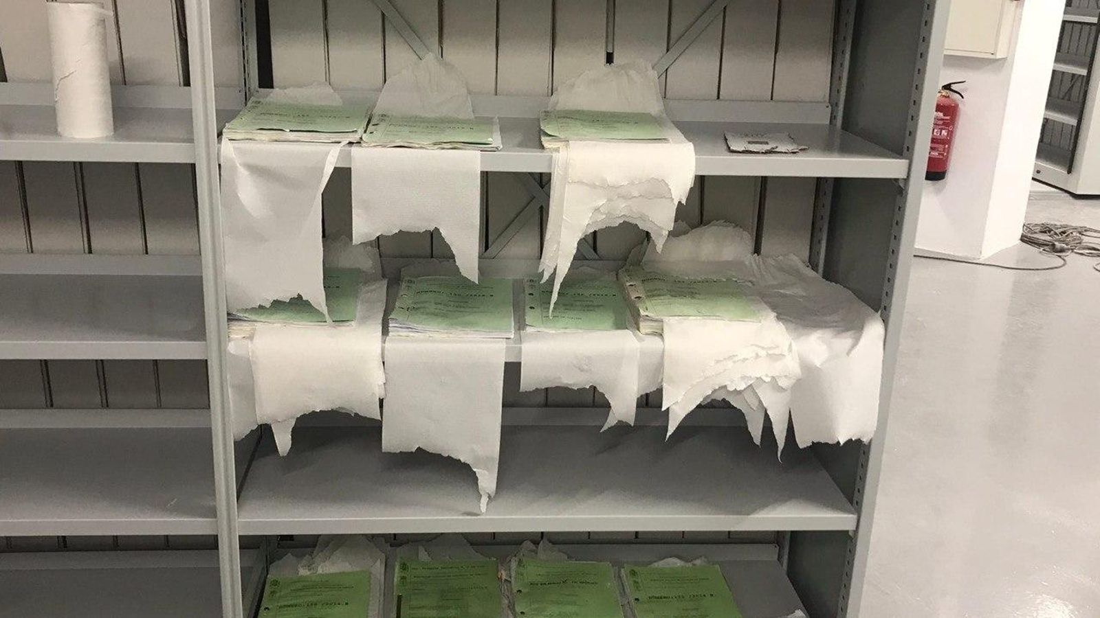 Expedientes afectados por las filtraciones de agua 'secando' con papel de manos.