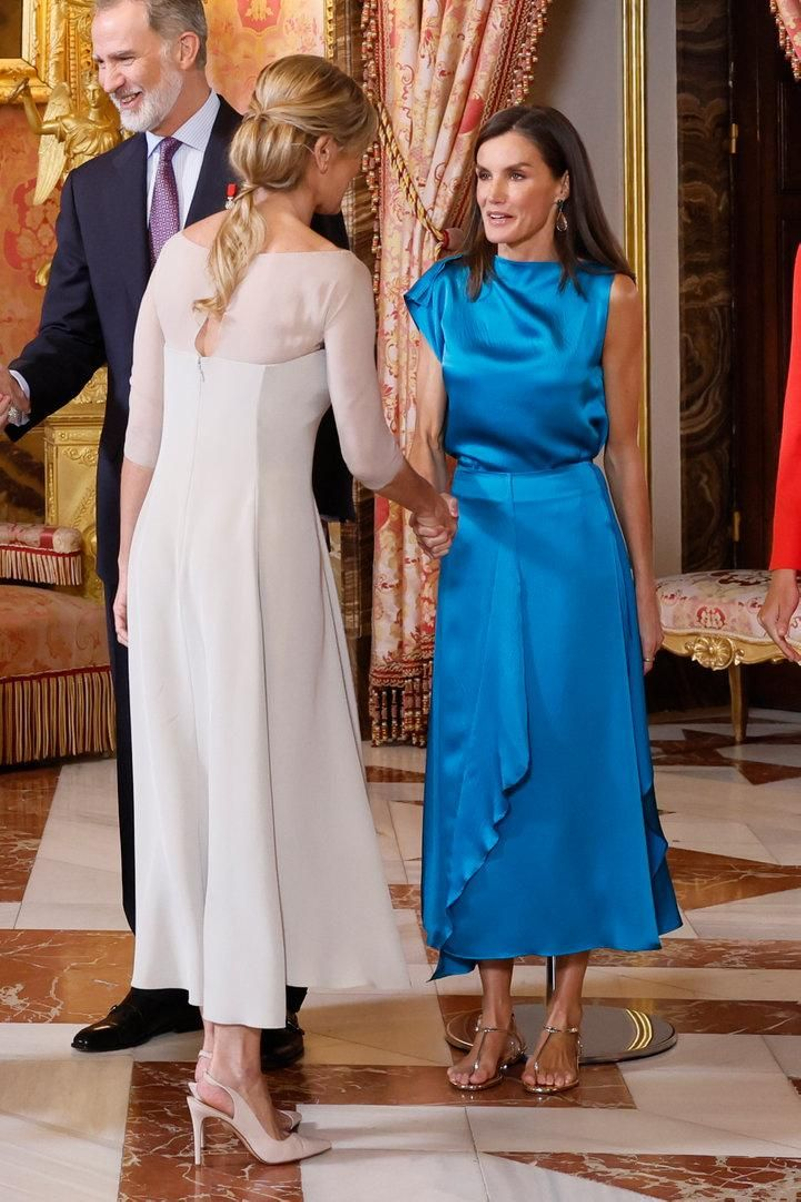 La reina Letizia saluda a Begoña Gómez, esposa del presidente del Gobierno.