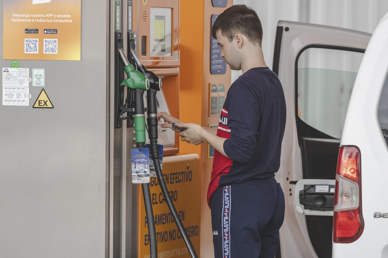 Un ourensano reposta carburante en una estación de servicio.