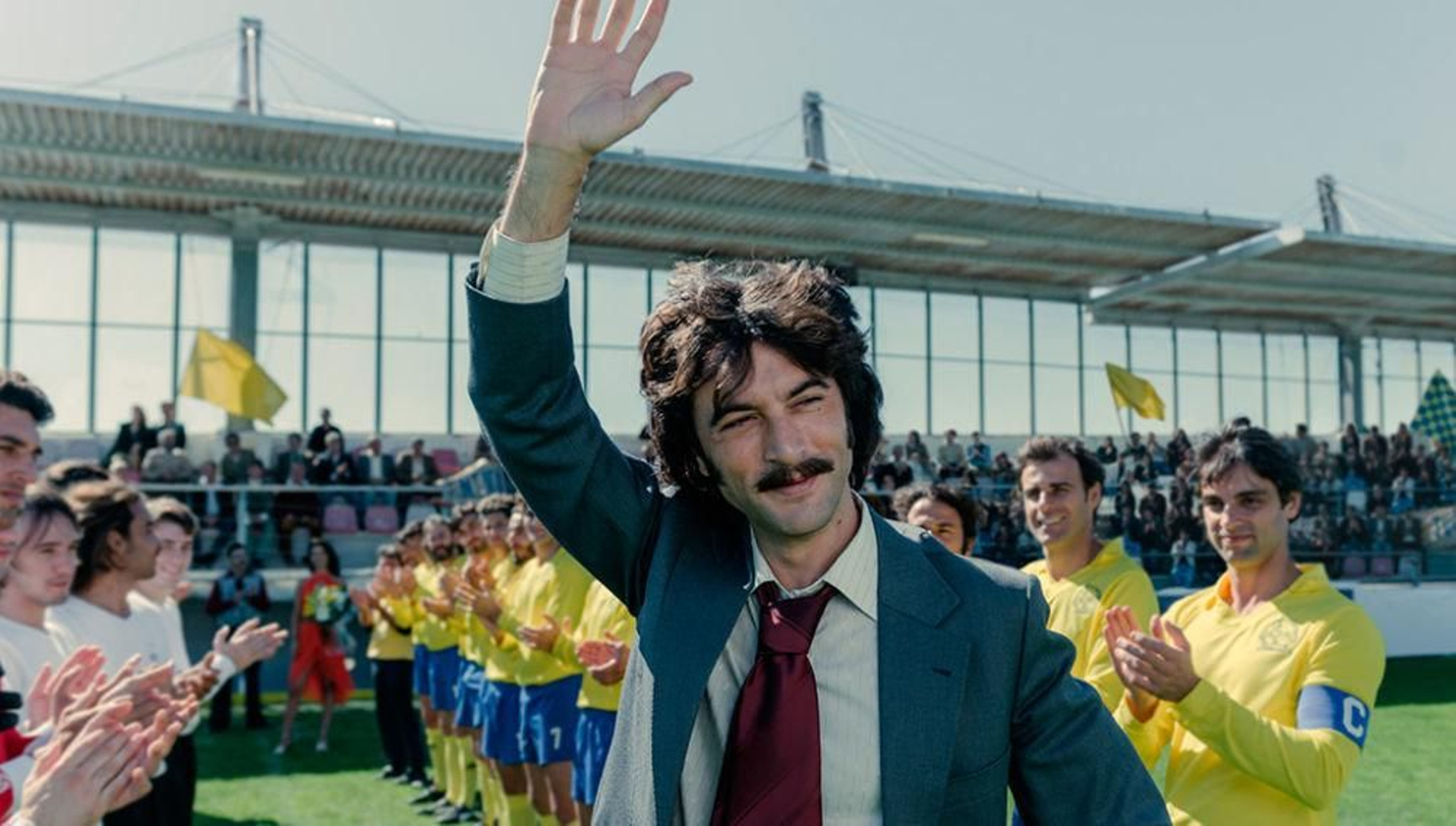 Javier Rey, en el papel de Sito Miñanco, saluda a cámara ante los aplausos de los jugadores del Cambados entre ellos Iván González, segundo en la parte derecha de la foto.