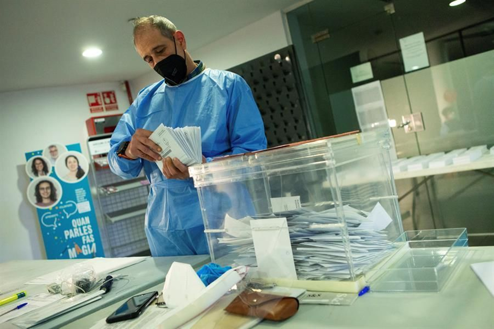 Un miembro de la mesa electoral de El Masnou, con el EPI, hace el recuento de votos para las elecciones al Parlament de Catalunya