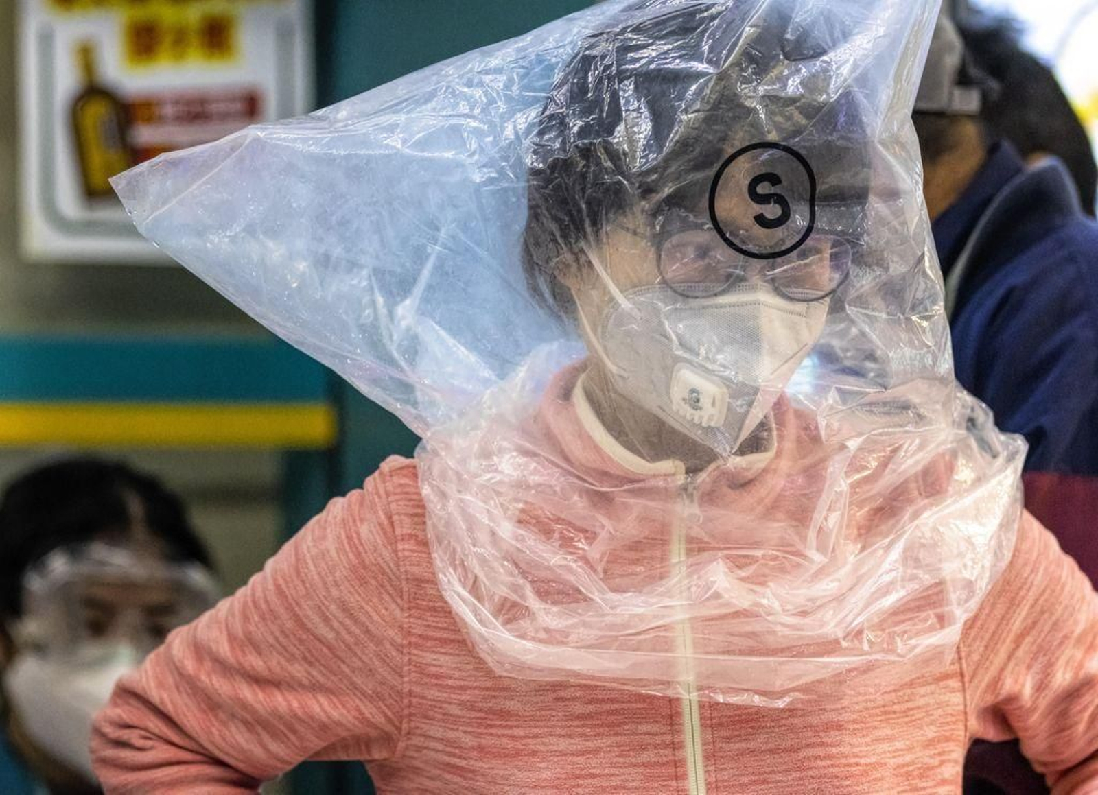 Una mujer cubre toda la cabeza con una bolsa de plástico.