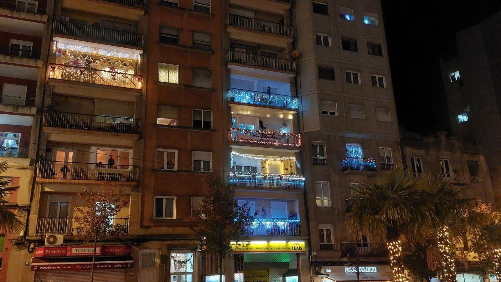 El edificio situado en la Travesía de Vigo lleno de luces de Navidad en los balcones.