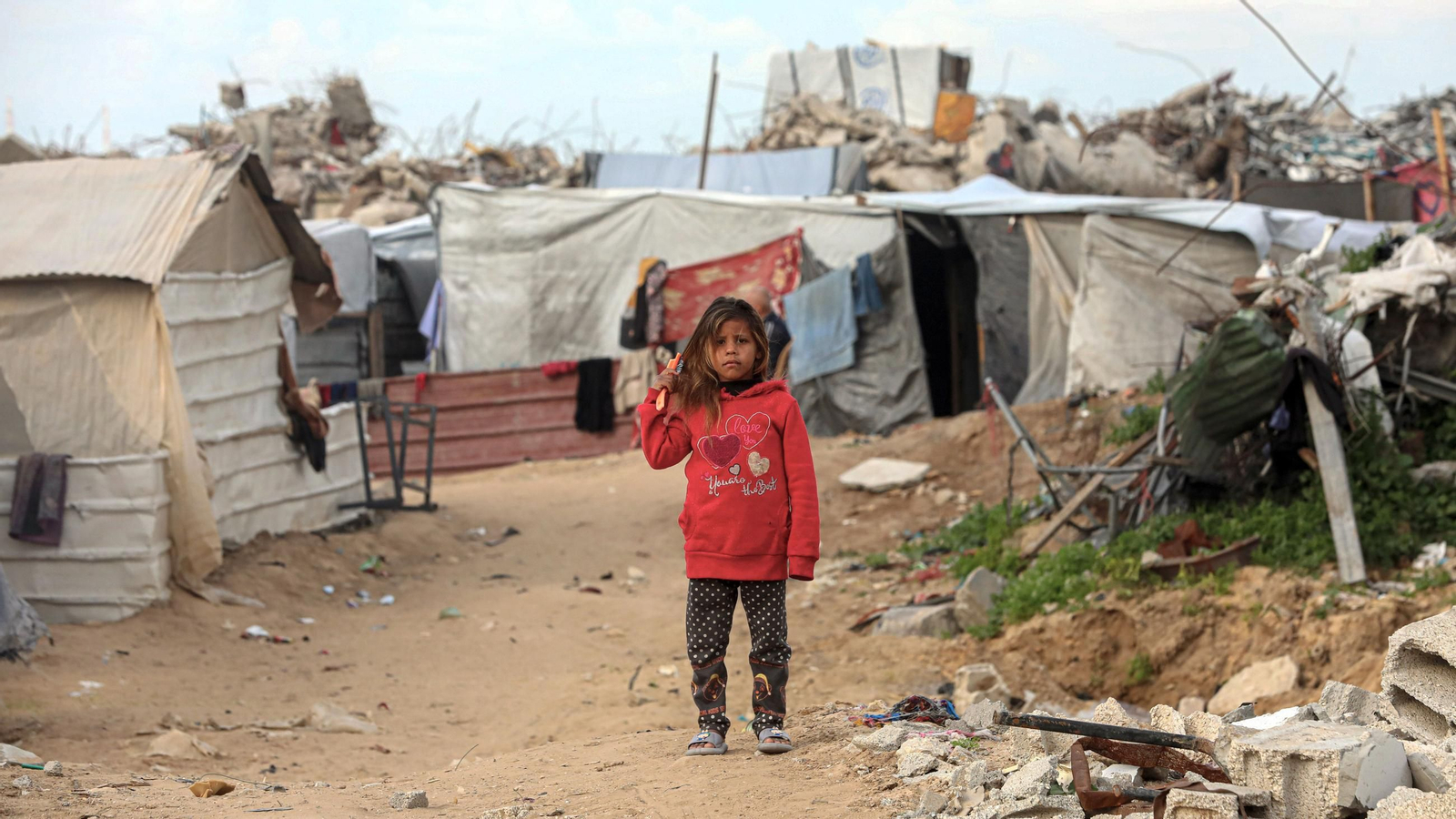 Un niño palestino es fotografiado cerca de una tienda de campaña entre casas destruidas en Beit Hanoun, en el norte de la Franja de Gaza.