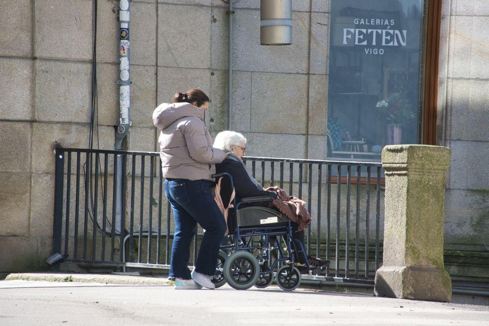 Una mujer pasea y cuida a una persona mayor en Vigo.
