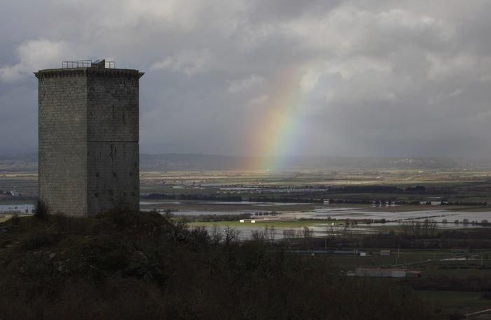 La Torre da Pena de A Limia, con un arco iris al fondo.