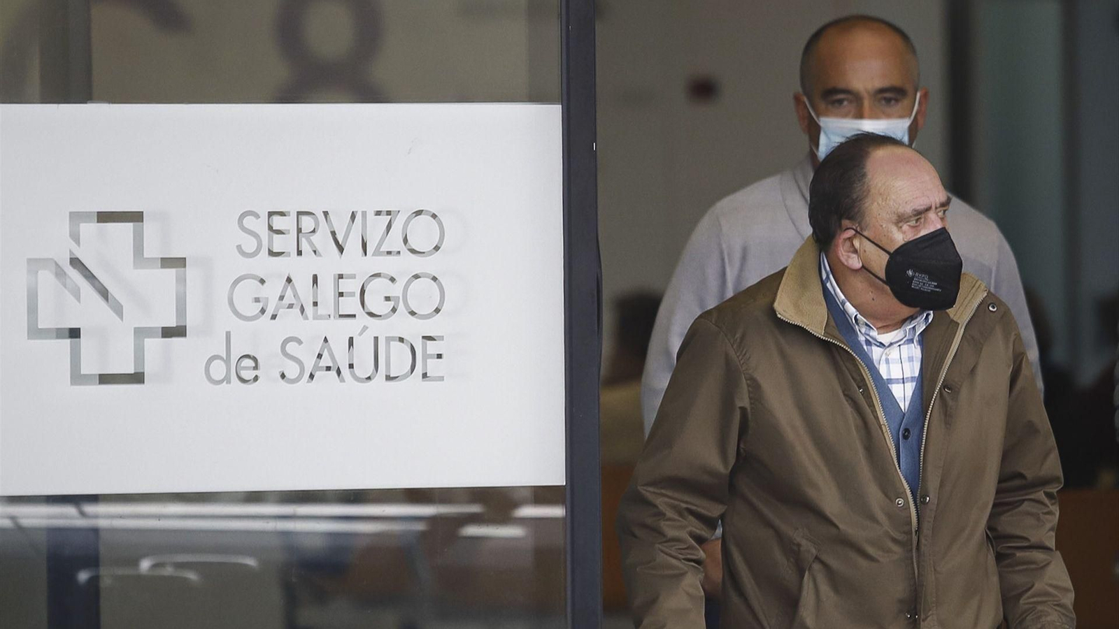 Dos hombres salen con mascarilla del Hospital Álvaro Cunqueiro de Vigo.
