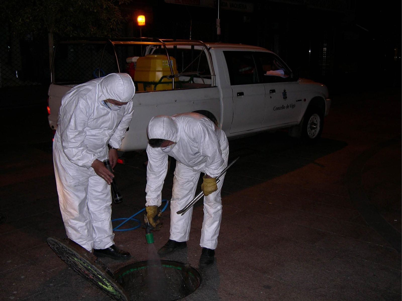 Operarios del Servicio de Control de Plagas realizando un tratamiento de desinsectación en la red de alcantarillado.