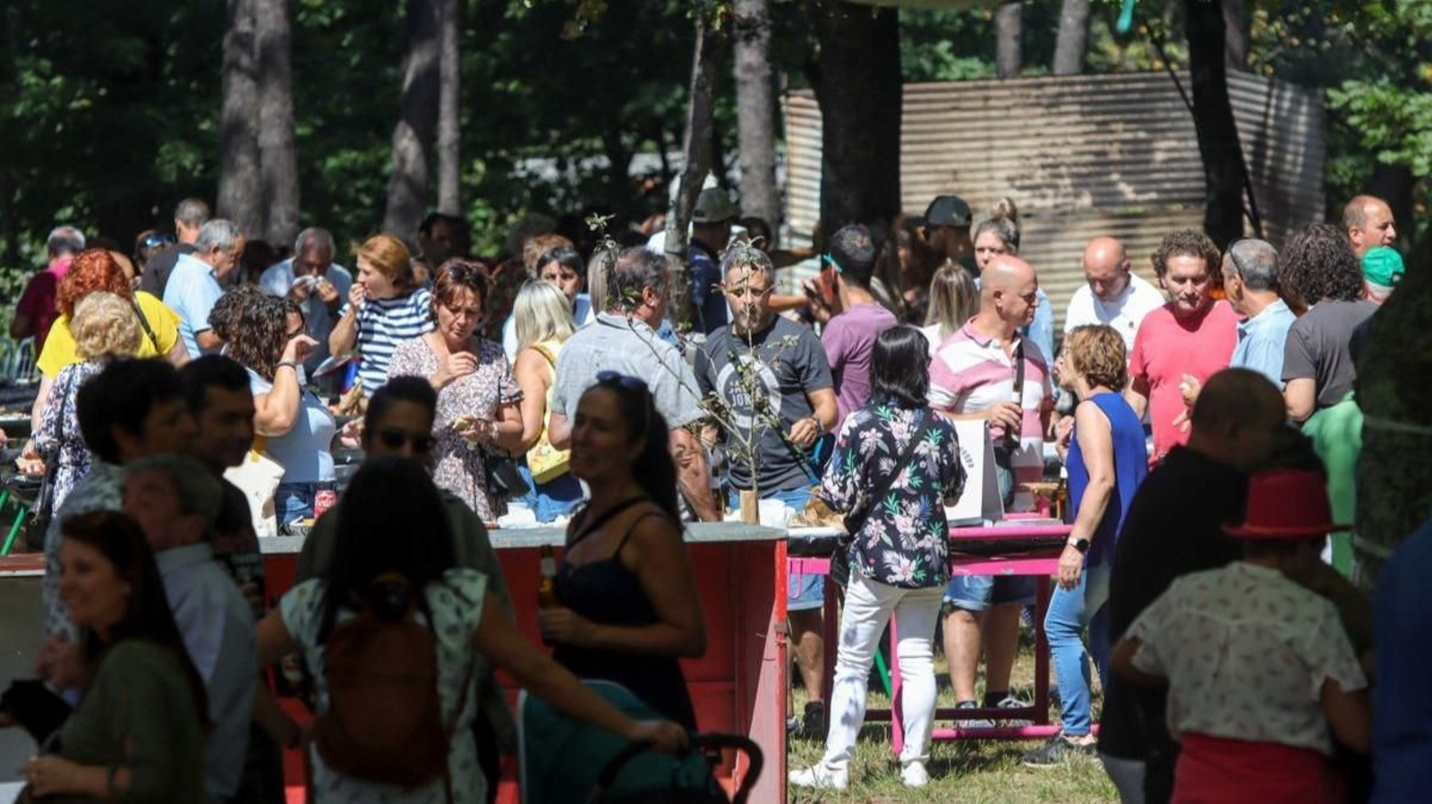 Los asistentes de la Romería do Pan de Millo comiendo y disfrutando de la música. Puesto de venta de pan de millo y empanadas.