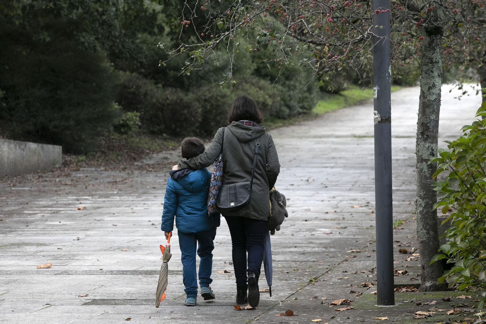 Una mujer paseando a solas con su hijo.