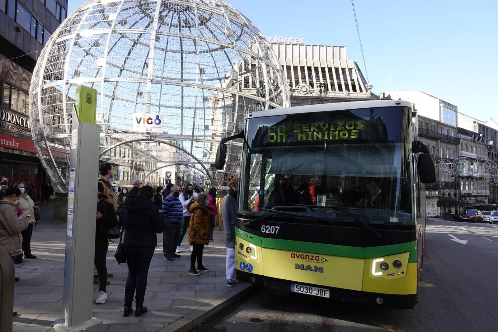 Un autobús con el cartel de servicios mínimos recoge a pasajeros en una parada del centro.