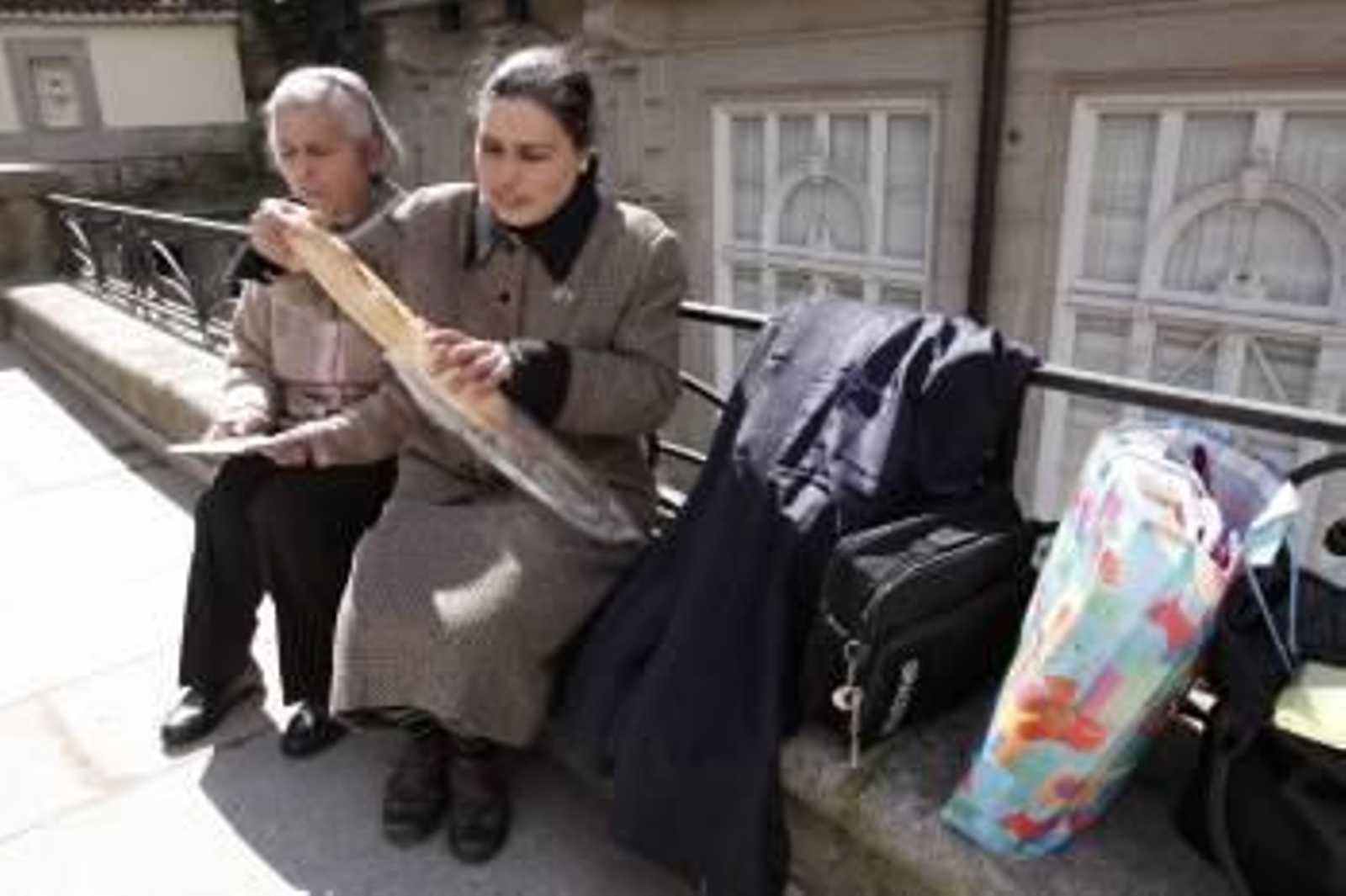Piedad y Carmen se disponen a comer en un muro de los Jardinillos del Padre Feijóo. (Foto: Xesús Fariñas)