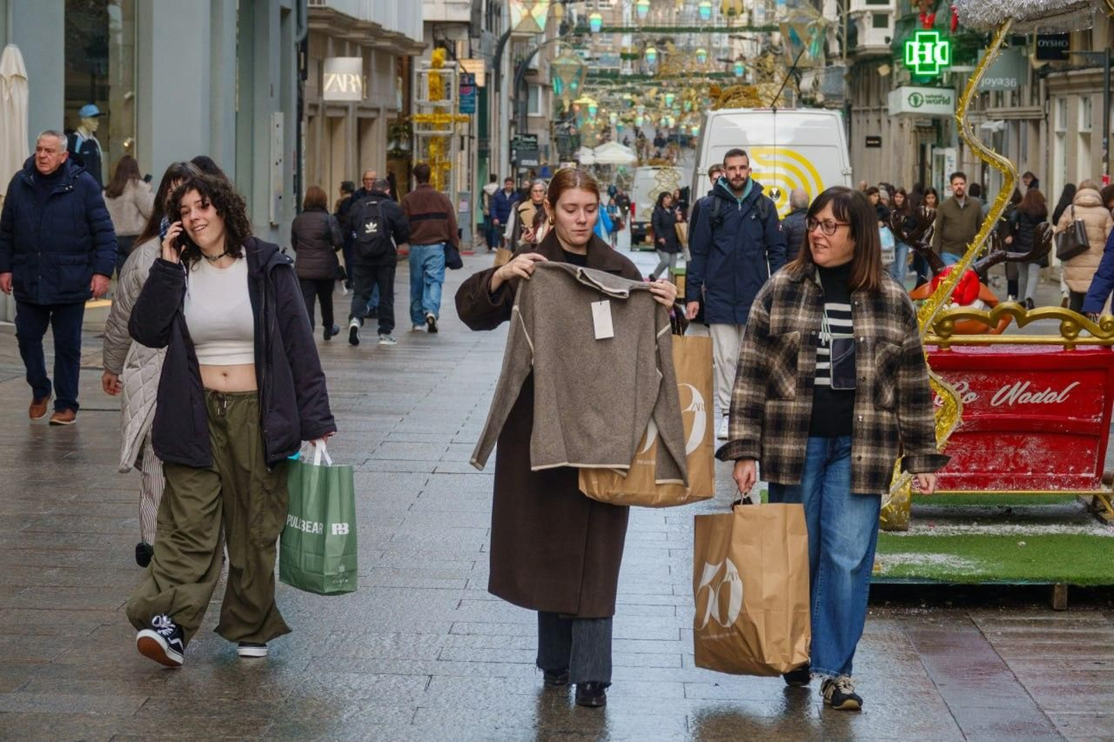 Gente por el centro de Vigo con sus compras de rebajas.