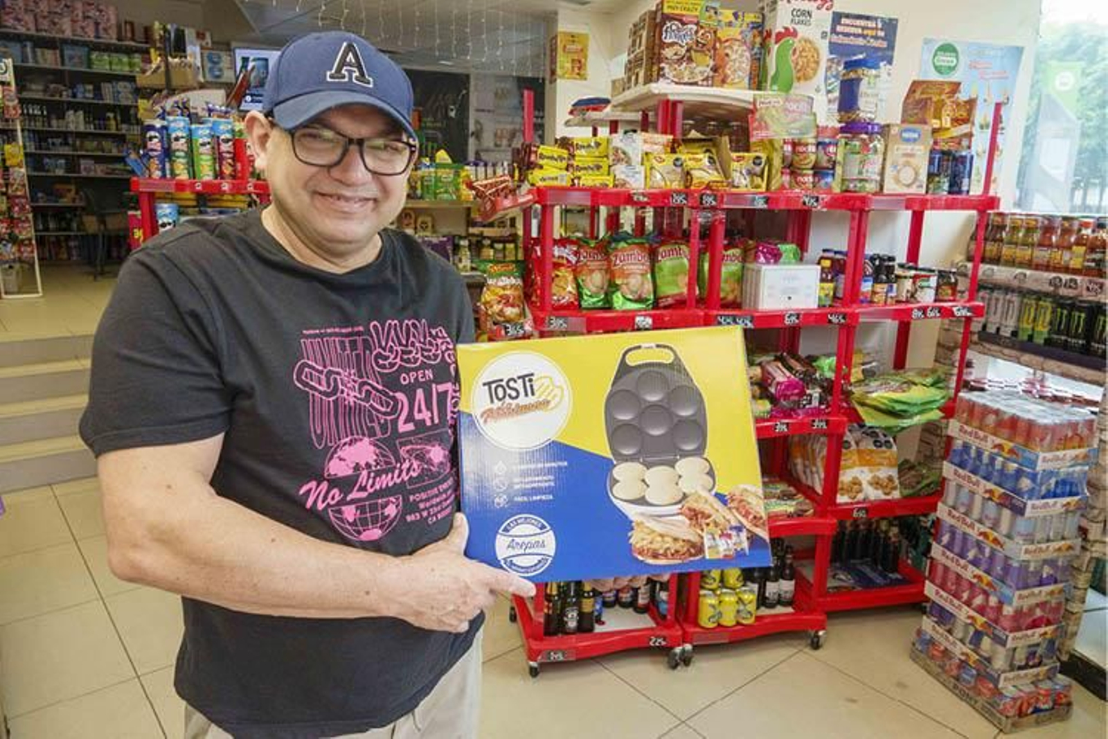 Alberto Zubero, dueño de “Alberto's Vigovenez”, posa con una máquina para hacer arepas.