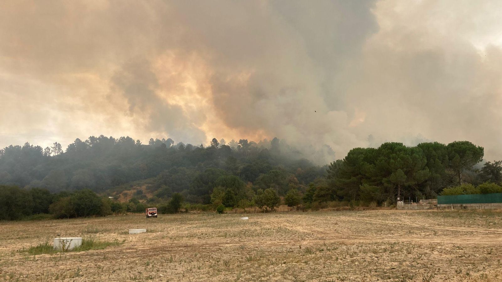 Los bomberos cruzan el campo para llegar al fuego