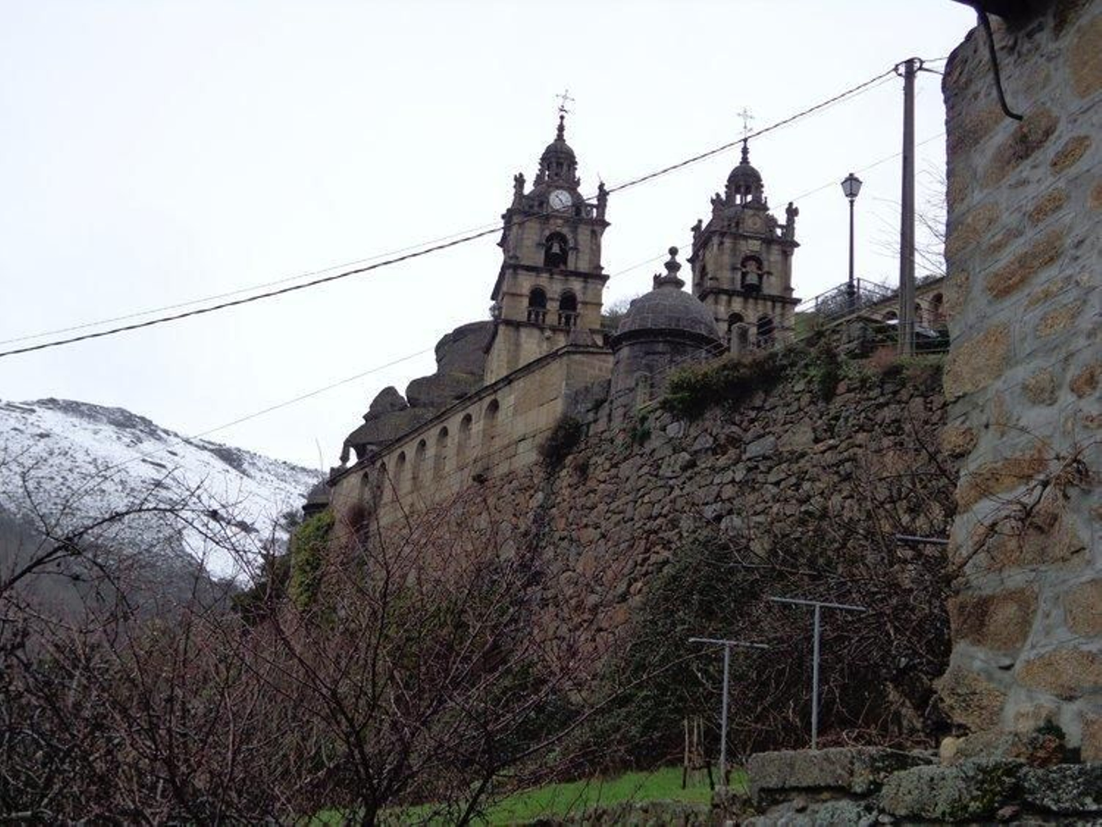 La maleza impide ver el muro derruido, próximo al que sujeta el santuario de As Ermidas.